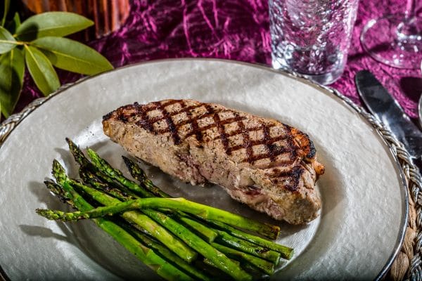new york steak and asparagus on a plate