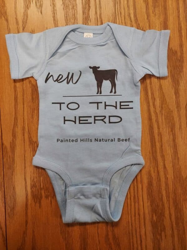 new to the herd onesie in light blue on a wooden surface Western baby onesies