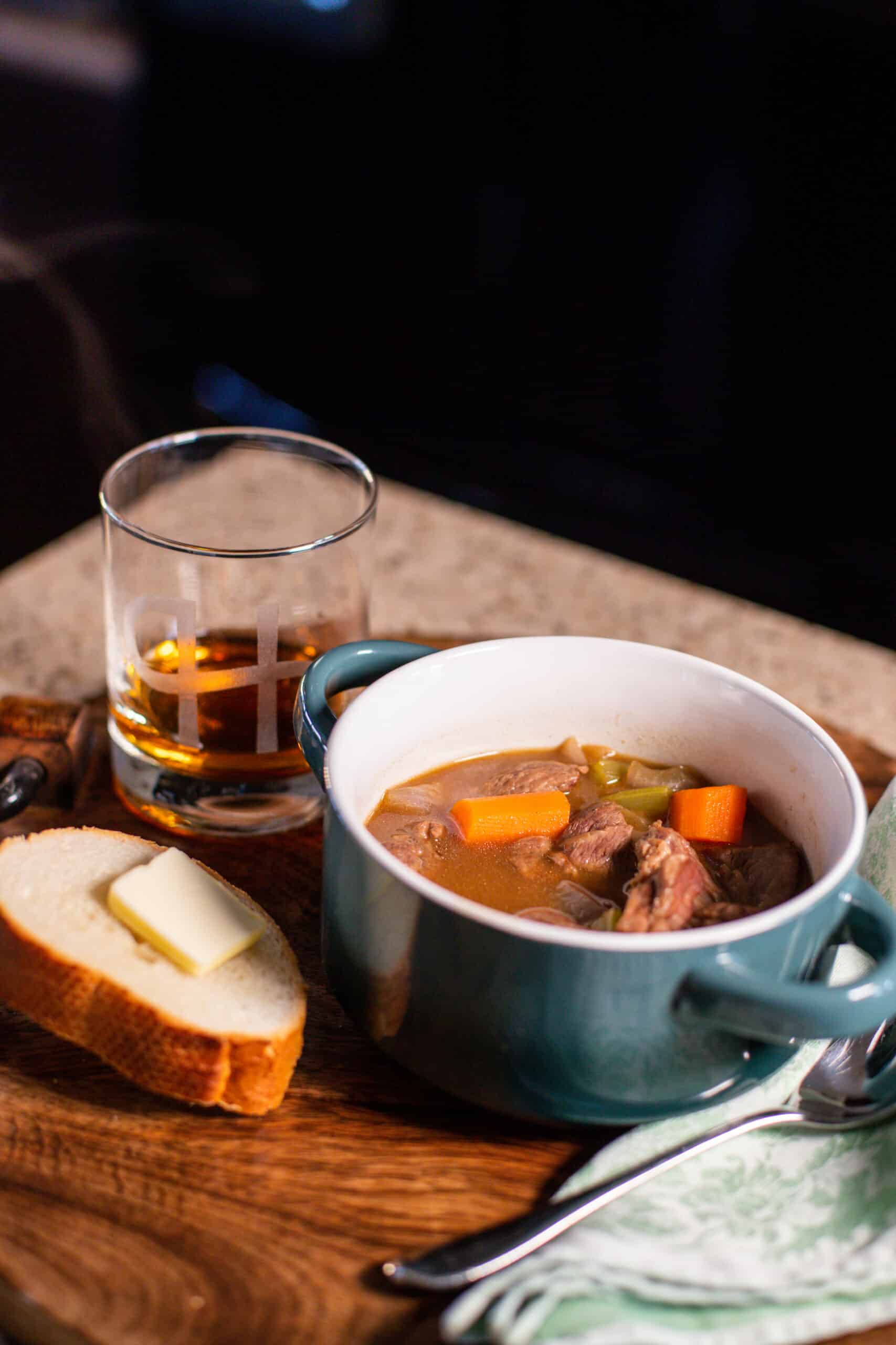 Whiskey Stew in a bowl with bread and butter on the side